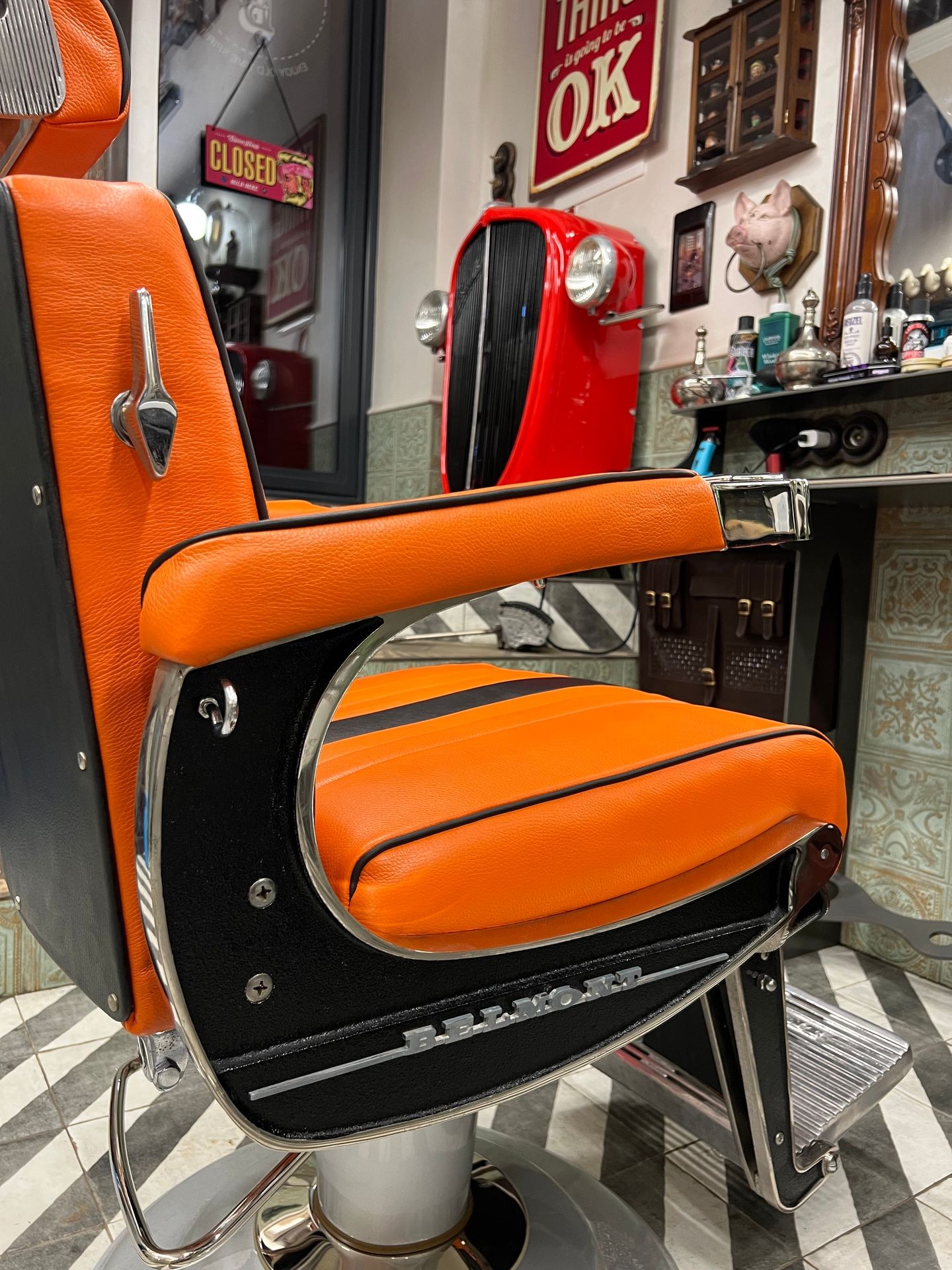 Vintage barber chair with orange upholstery in a retro-styled barbershop.